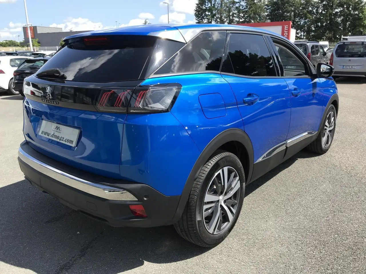 Peugeot 3008 bleu Iron vue 3/4 arrière droit, vitres surteintées et jantes alliage bi-ton visibles.