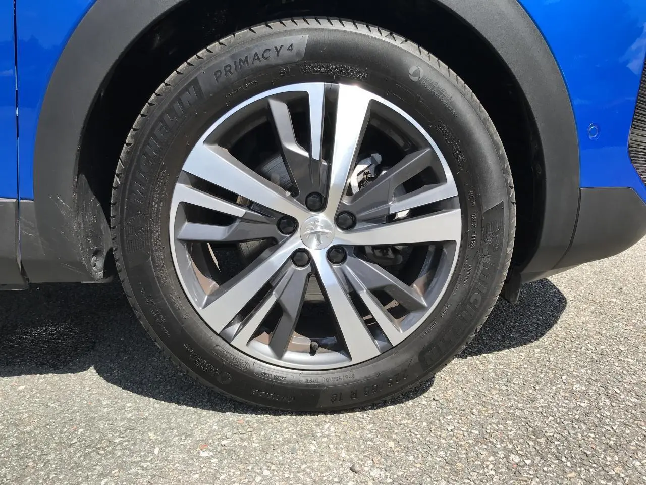 Gros plan sur la jante alliage 18 pouces bi-ton diamantée Gris Storm du côté droit d’un Peugeot 3008 Bleu Iron.