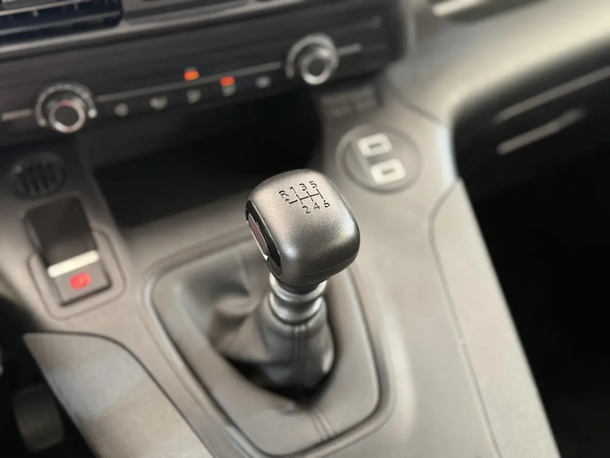 Le levier de vitesses manuel noir du Peugeot Rifter 1.5 BlueHDi 100, vue rapprochée de l'intérieur.