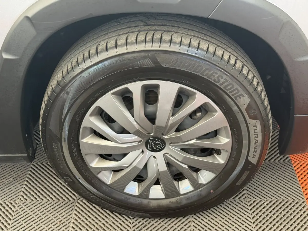 Gros plan sur la roue avant gauche du Peugeot Rifter gris clair, avec jante en alliage et pneu Bridgestone Turanza.