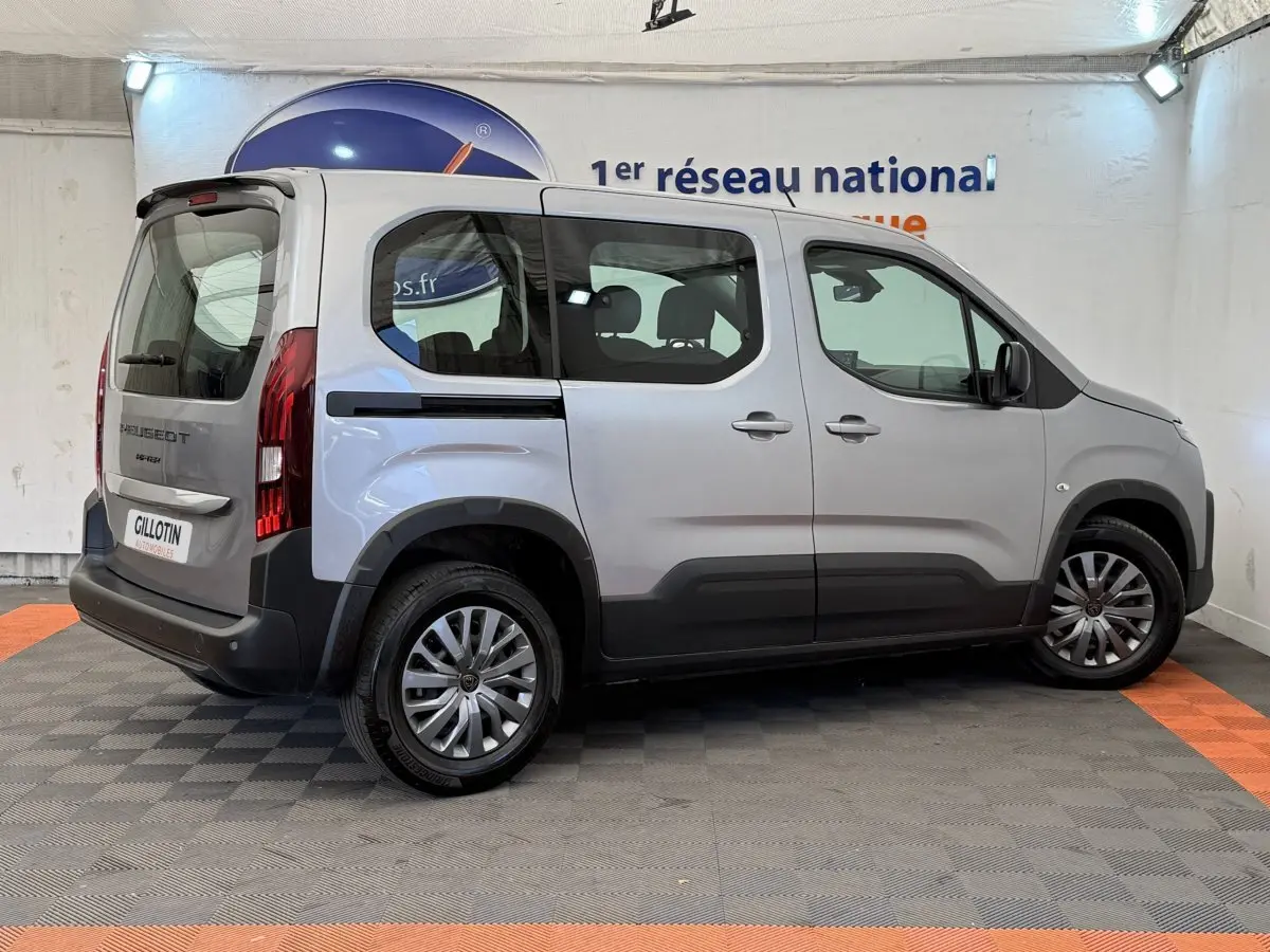 Peugeot Rifter gris clair vue de profil côté droit, avec jantes alliage et vitres teintées arrière.