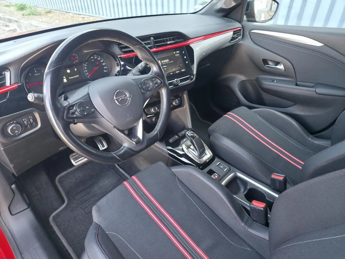 Vue intérieure avant droite de l’Opel Corsa GS Line 2020, sièges sport noirs avec bandes rouges et volant cuir multifonction.