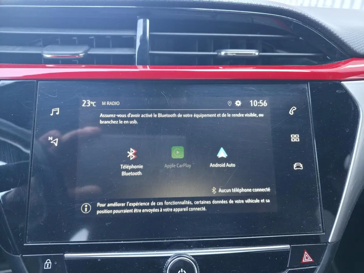 Écran tactile central de l’Opel Corsa rouge, affichant options Bluetooth, Apple CarPlay et Android Auto.