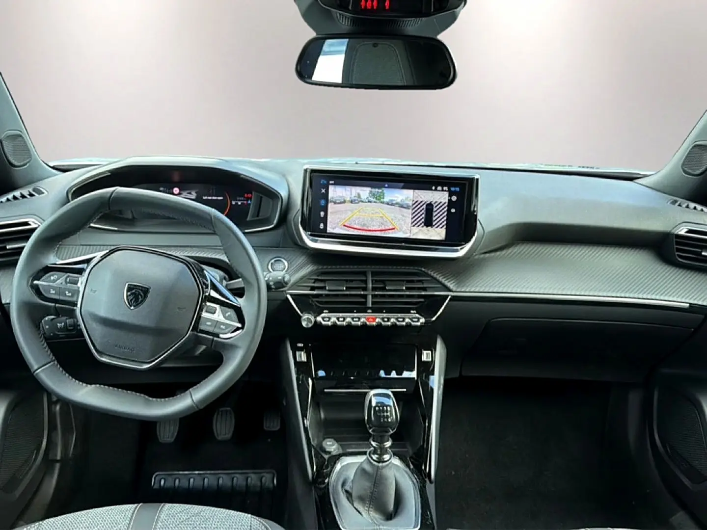 Vue intérieure avant du Peugeot 2008 1.2 100 allure avec volant multifonction, écran tactile et levier de boîte manuelle.
