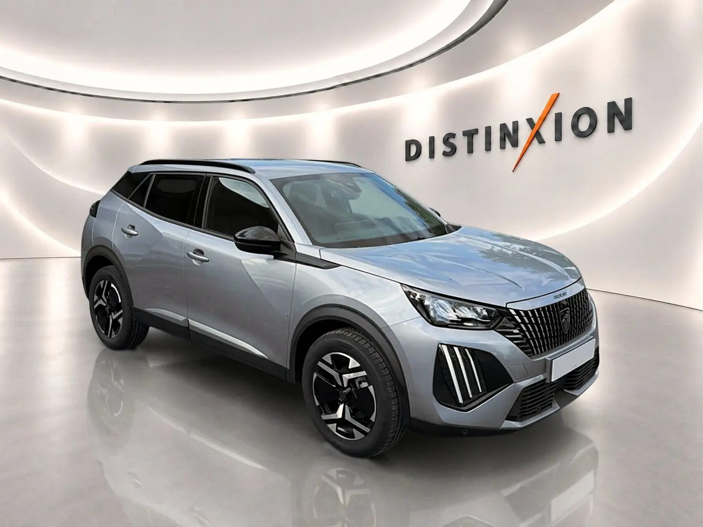 Peugeot 2008 gris artense vue 3/4 avant droit en intérieur avec jantes alu et toit noir contrasté.