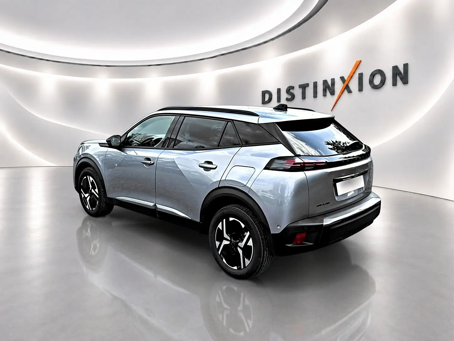 Peugeot 2008 gris Artense en 3/4 arrière droit, avec jantes alu noires et toit noir dans un showroom lumineux.