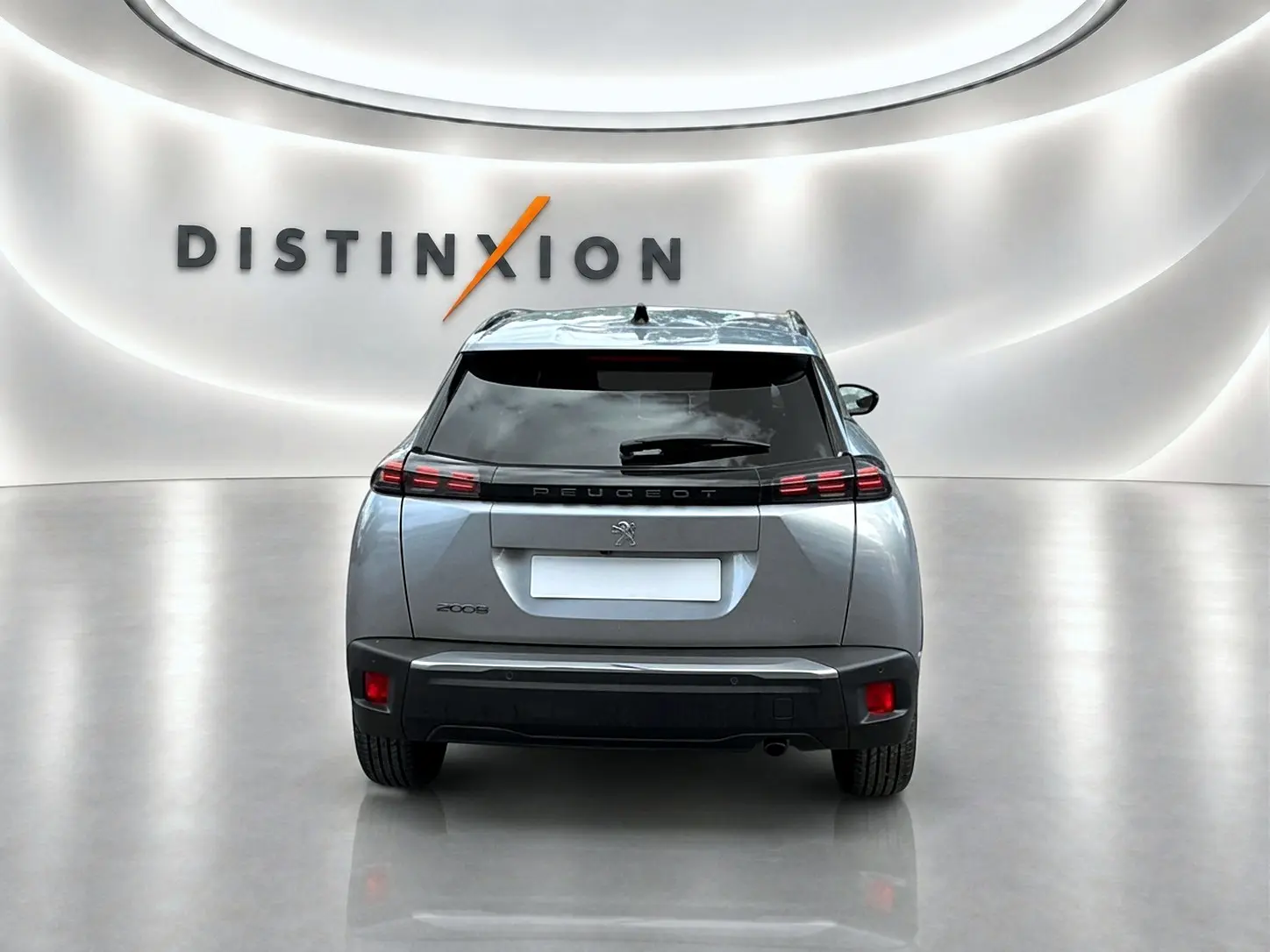Vue arrière centrée du Peugeot 2008 gris Artense 2025 avec feux LED et lunette arrière teintée dans un showroom lumineux.