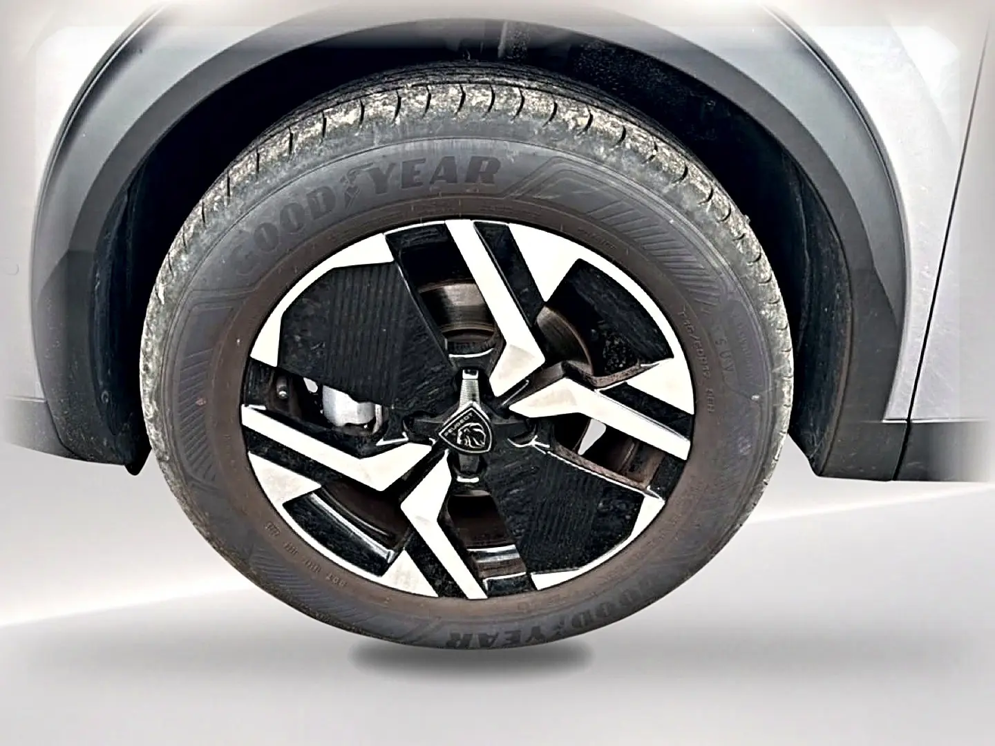 Gros plan sur la roue avant gauche gris artense du Peugeot 2008 1.2 100 allure avec jante alu bicolore distinctive.