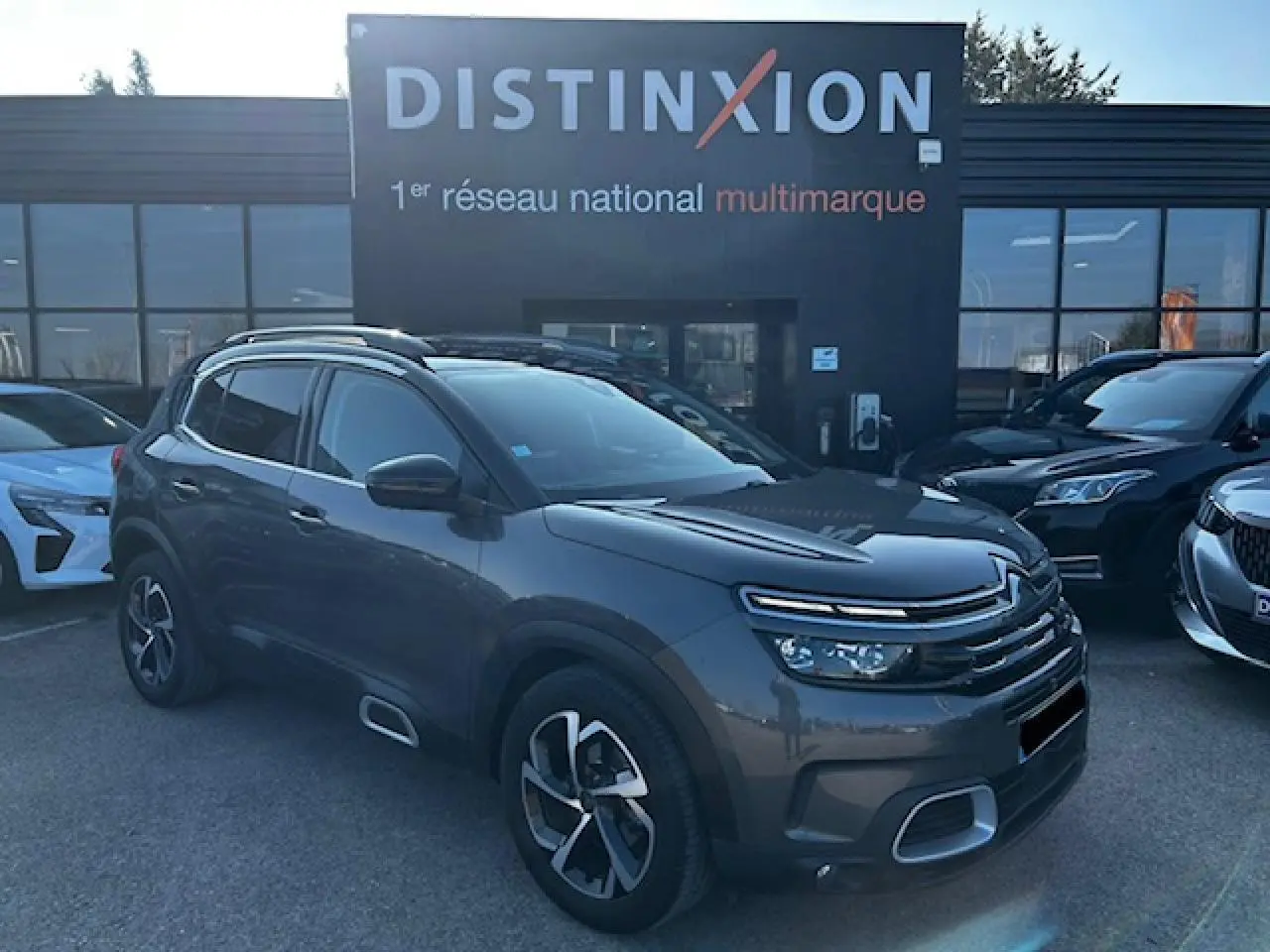 Citroën C5 Aircross gris platinium métallisé en 3/4 avant droit avec jantes alliage et barres de toit bi-ton.