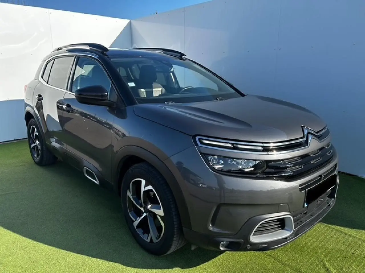 Citroën C5 Aircross gris platinium métal en 3/4 avant droit avec jantes alliage et barres de toit noires.