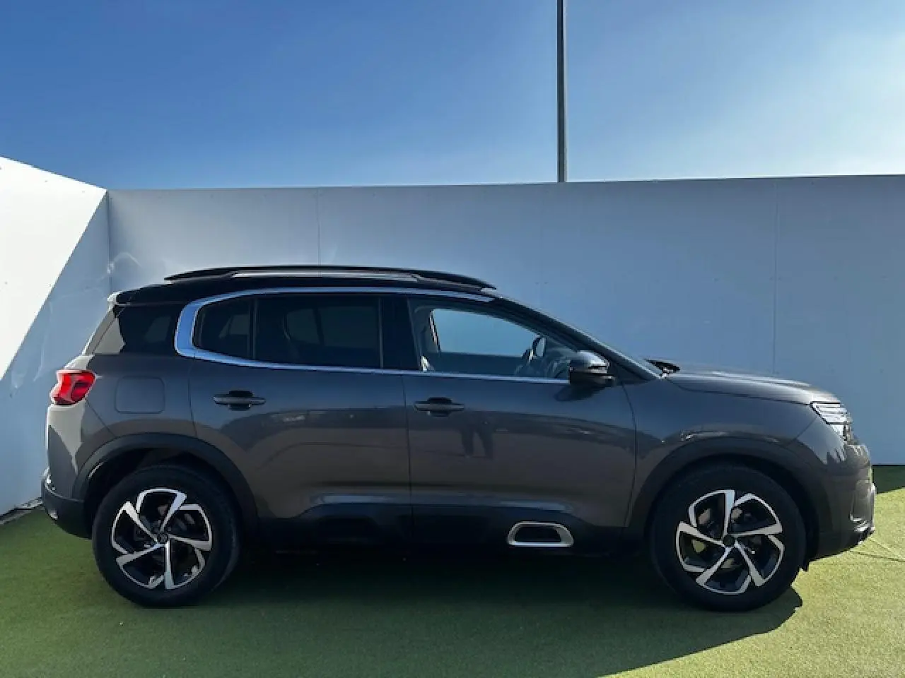 Profil côté gauche du Citroën C5 Aircross gris platinium métallisé avec jantes alliage et vitres surteintées.