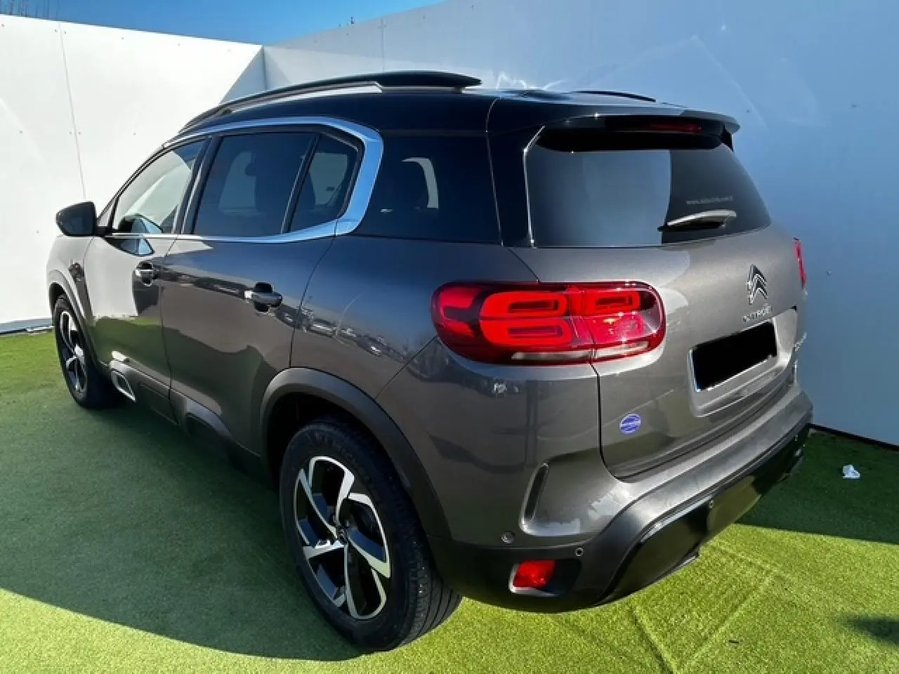 Vue 3/4 arrière droite du Citroën C5 Aircross gris platinium métallisé avec feux arrière LED et jantes alliage 18 pouces.