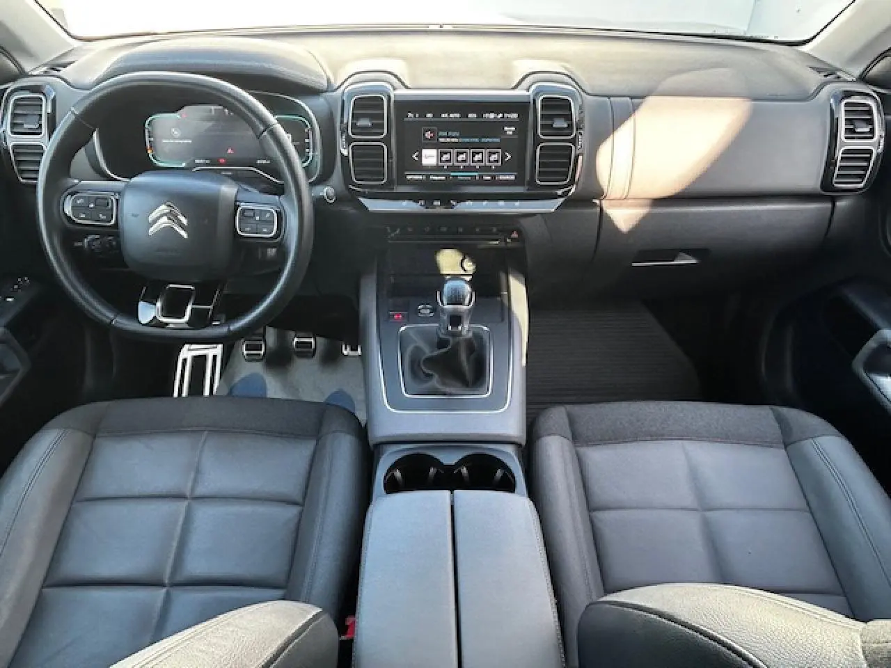 Vue intérieure avant du Citroën C5 Aircross 2019, tableau de bord noir avec volant cuir et levier de vitesse manuel.