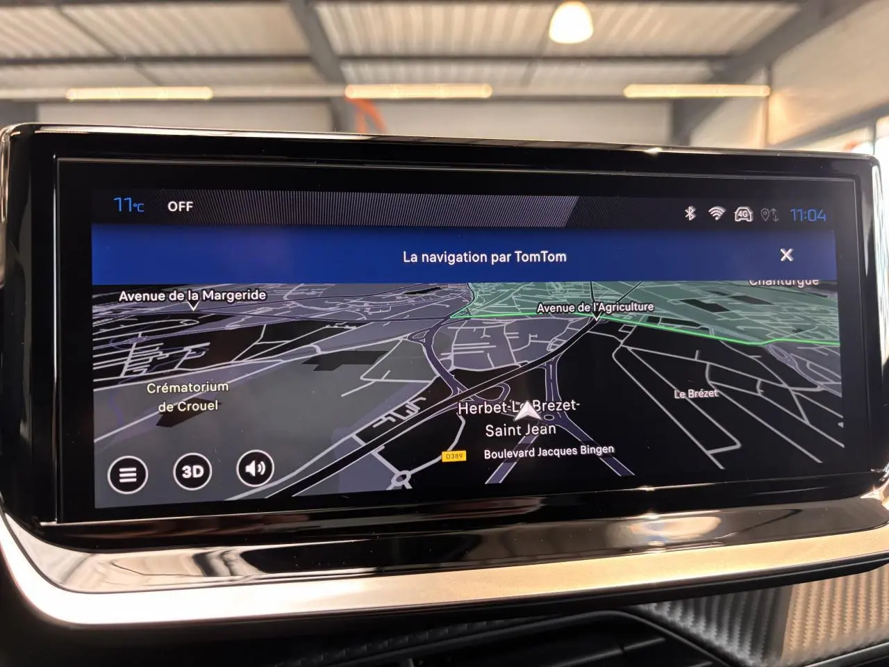 Écran tactile de navigation TomTom affichant une carte en mode 3D dans l'habitacle du Peugeot 2008 noir.