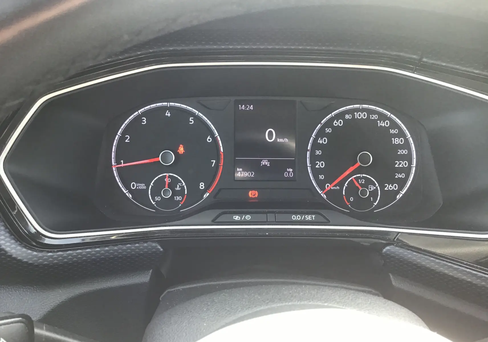 Vue rapprochée du tableau de bord numérique du Volkswagen T-Cross blanc, affichant vitesse et compte-tours.