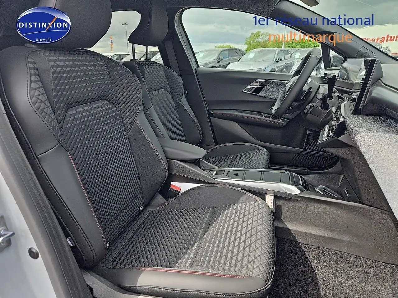 Vue intérieure côté gauche de la Renault Clio VI 1.2 TCe 115 Techno avec sièges noirs matelassés et accoudoir central.