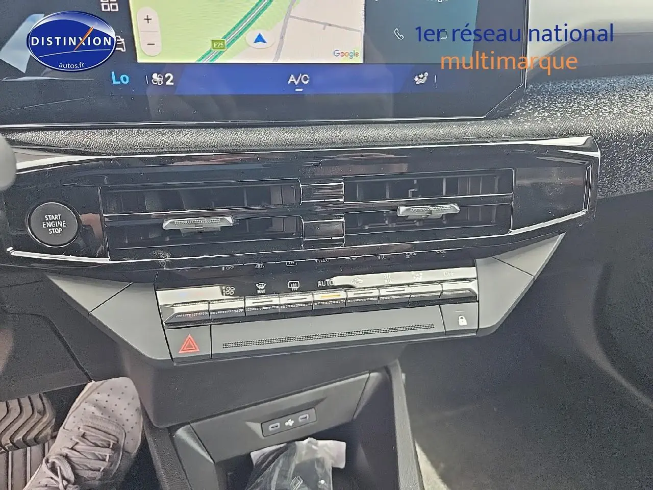 Vue rapprochée du tableau de bord de la Renault Clio VI gris rafale, avec écran tactile et commandes de climatisation.