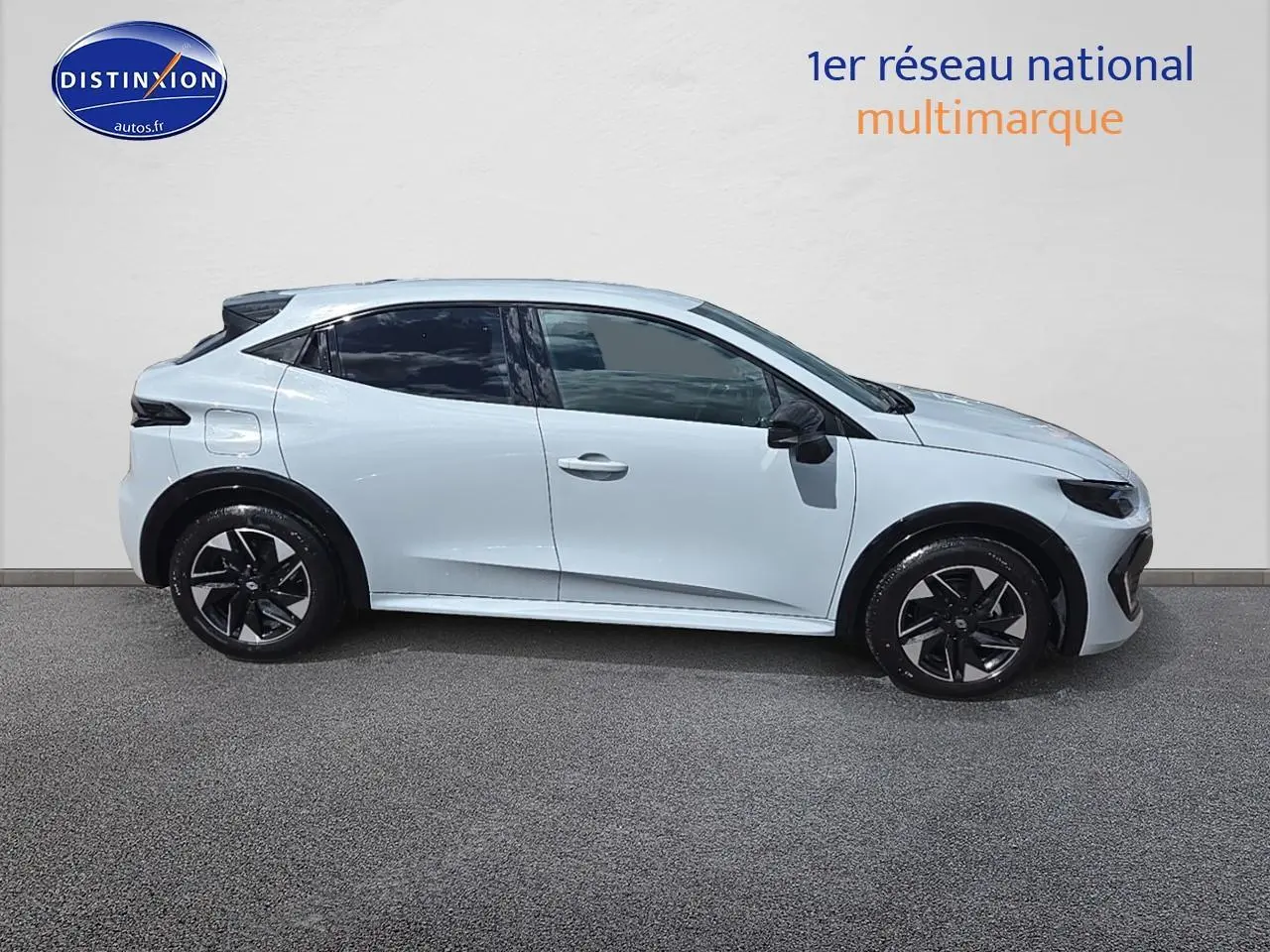 Profil droit de la Renault Clio VI gris rafale 2026, jantes alliage noires et vitres teintées visibles.