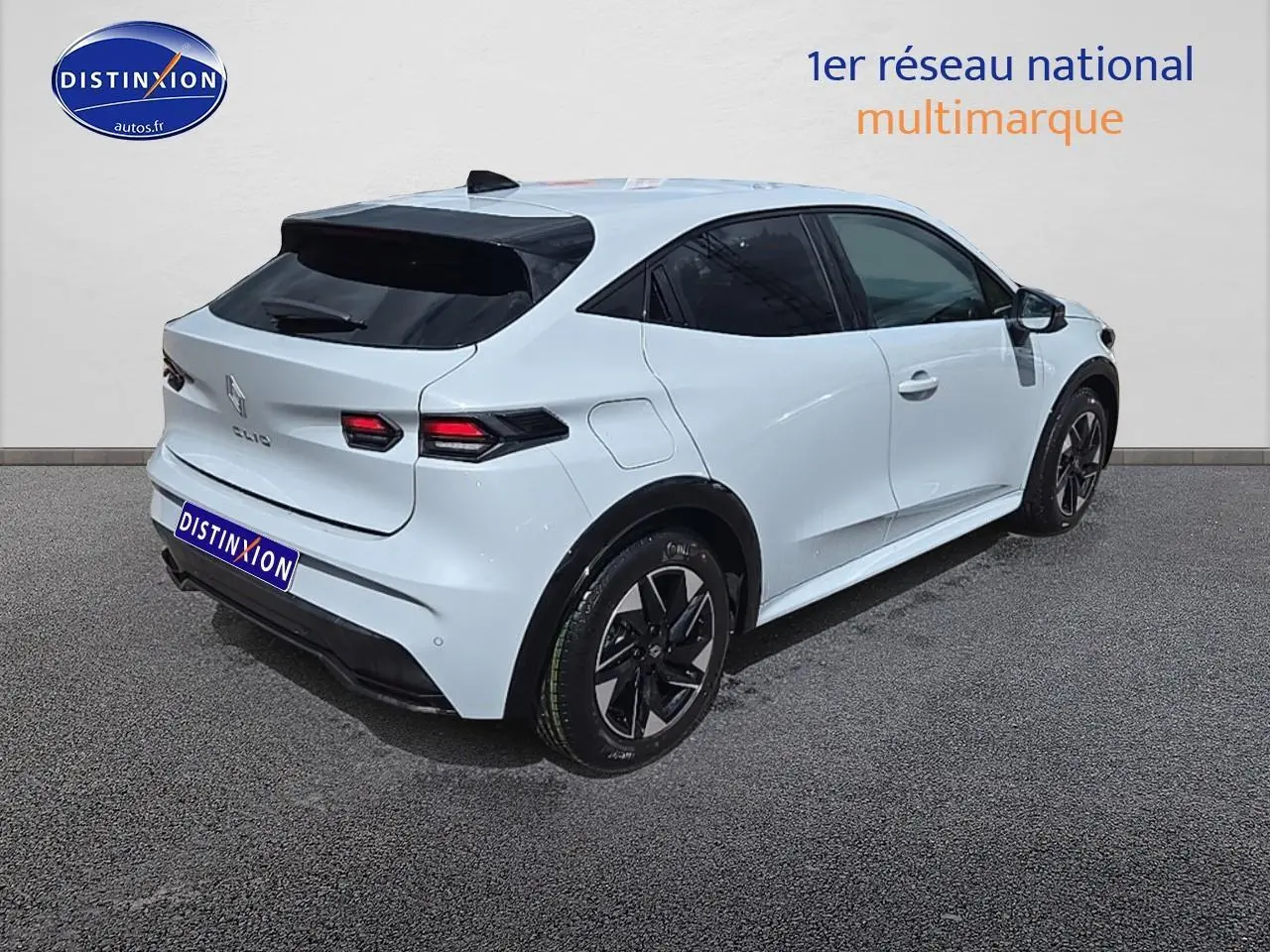 Vue 3/4 arrière droite d'une Renault Clio VI blanche avec vitres teintées et jantes alliage noires.