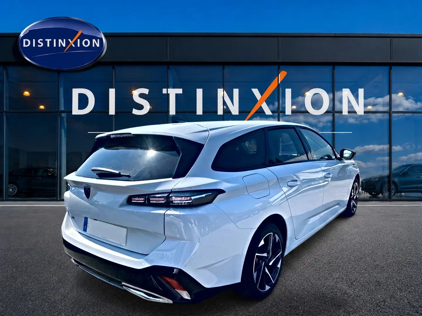 Vue 3/4 arrière droite d'une Peugeot 308 SW blanche 2025, avec feux arrière LED et jantes alliage distinctives.