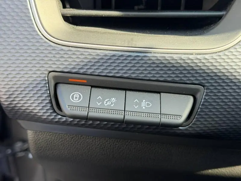 Détail intérieur des commandes de réglage des phares et verrouillage sur Renault Arkana gris métallisé 2025.