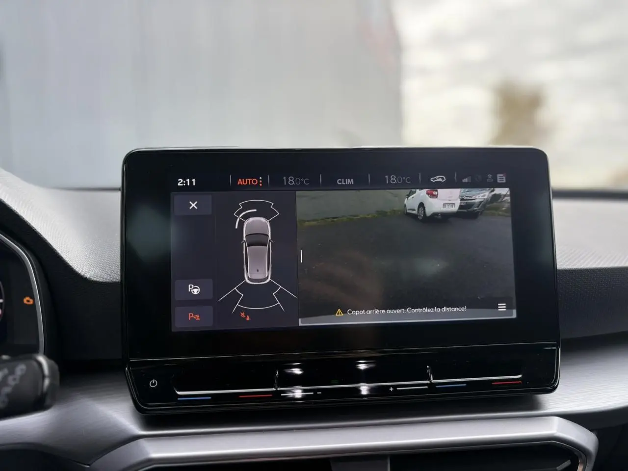 Écran tactile central de la SEAT LEON 2024 montrant la caméra de recul et l'alerte capot arrière ouvert.