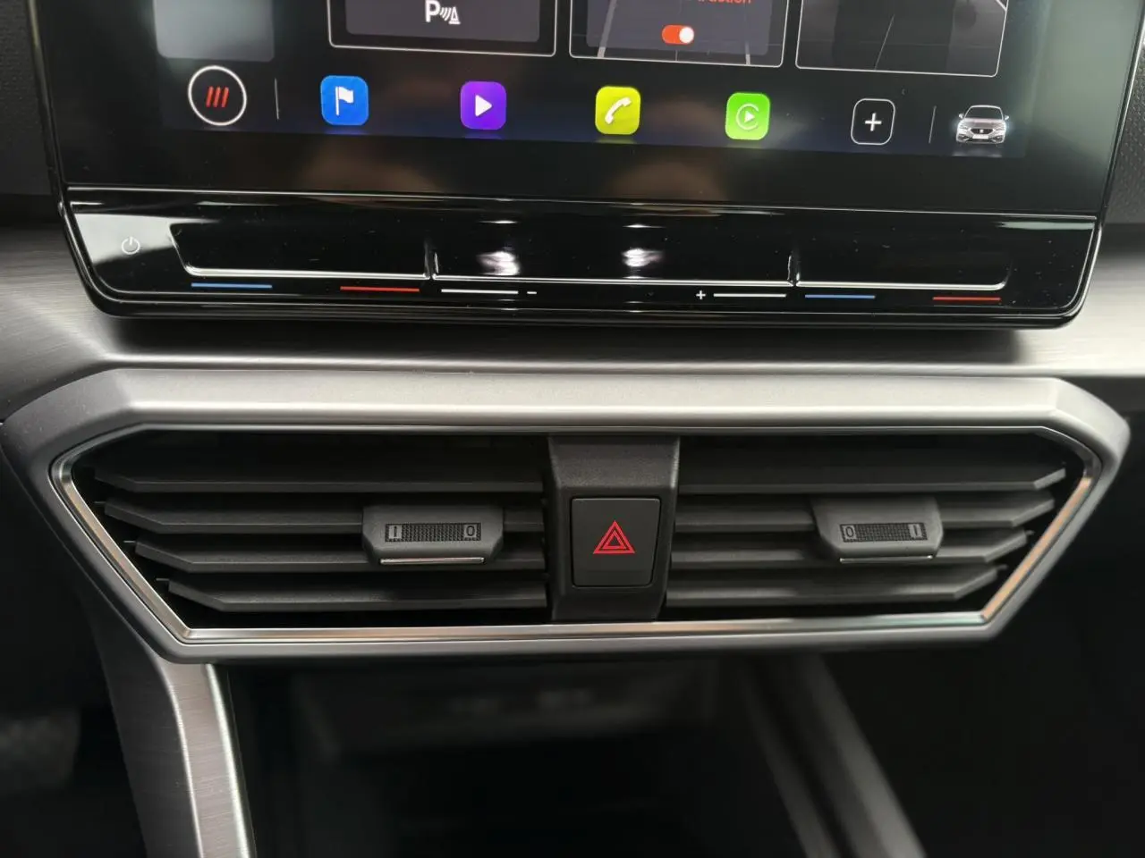 Détail de la console centrale du SEAT LEON 1.5 e-TSI 150 DSG7 FR 2024, montrant les aérateurs et commandes de climatisation.
