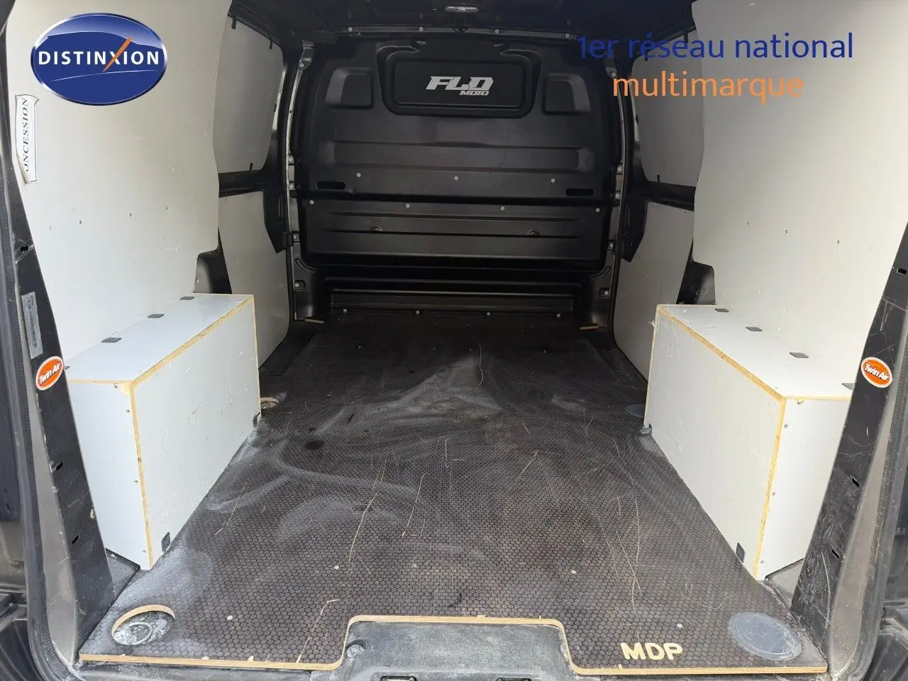 Vue arrière intérieure de l’Opel Vivaro gris titane, montrant l’espace de chargement avec planchers et protections latérales.