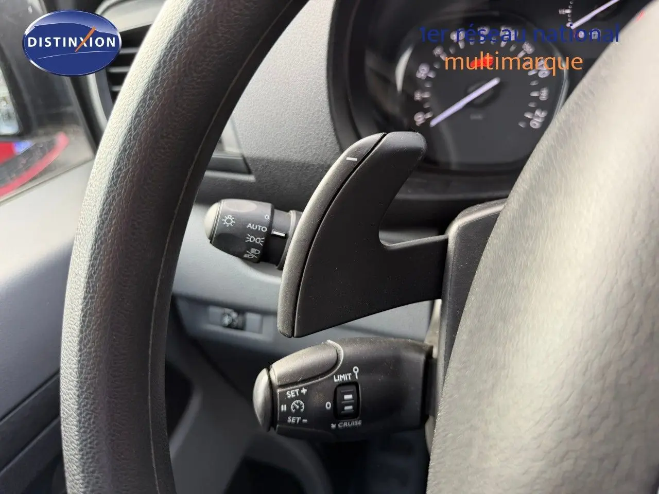 Gros plan sur le volant noir d’un Opel Vivaro 2020, mettant en valeur les commandes de régulateur de vitesse et la palette de changement.