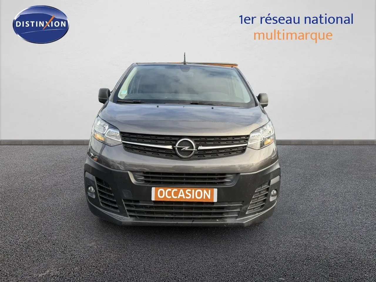 Vue frontale d'un Opel Vivaro gris titane métal avec plaque "OCCASION" sur fond neutre.