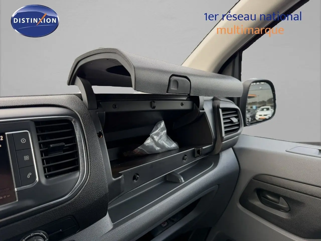 Intérieur de l’Opel Vivaro 2020 gris titane, vue côté passager avec boîte à gants ouverte et tableau de bord noir.