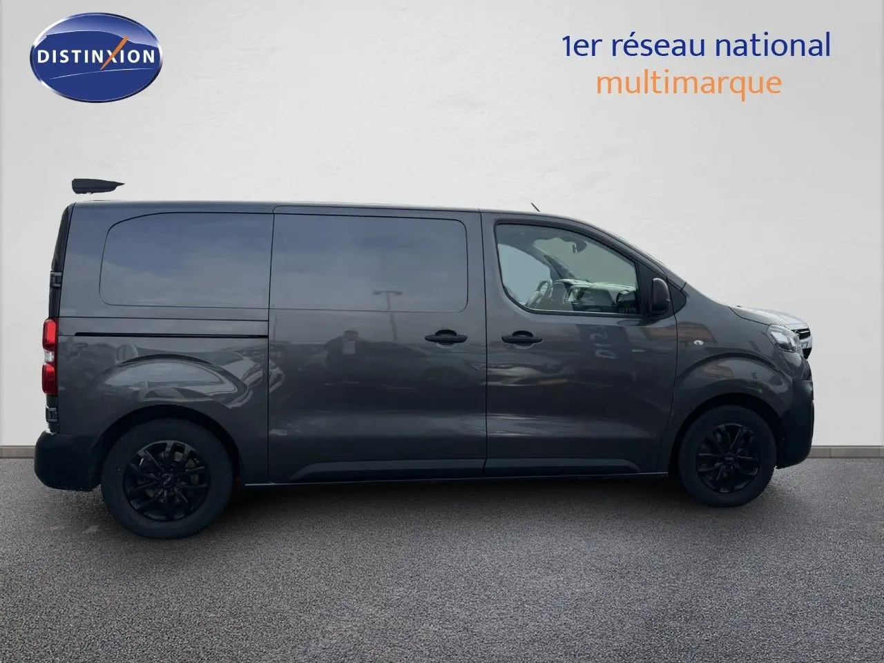 Opel Vivaro gris titane métal vu de profil côté gauche, fourgon utilitaire avec vitres teintées et jantes noires.