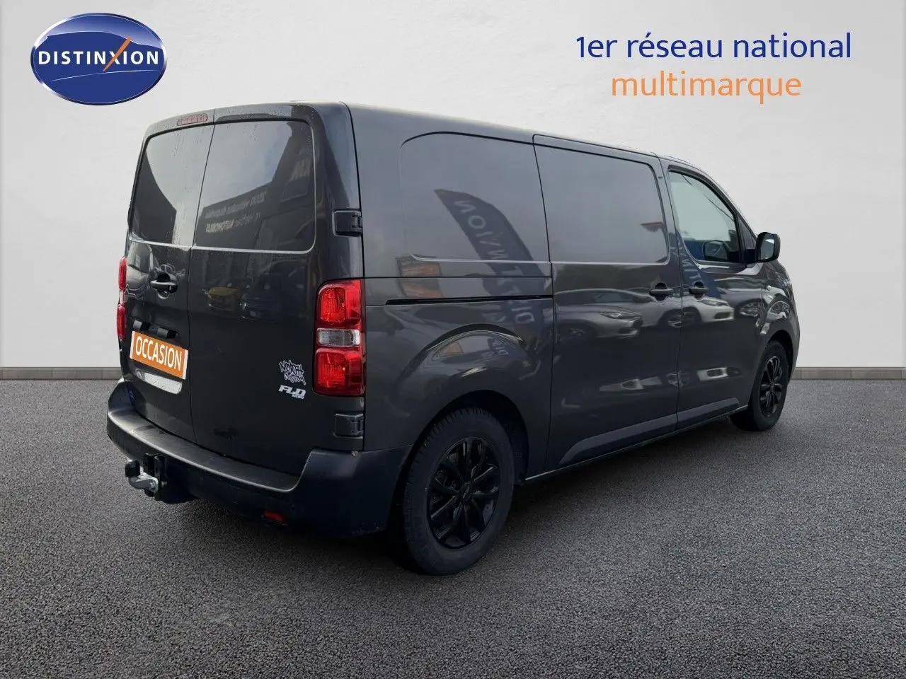 Vue 3/4 arrière droite d’un Opel Vivaro gris titane métallisé avec jantes noires et attelage visible.