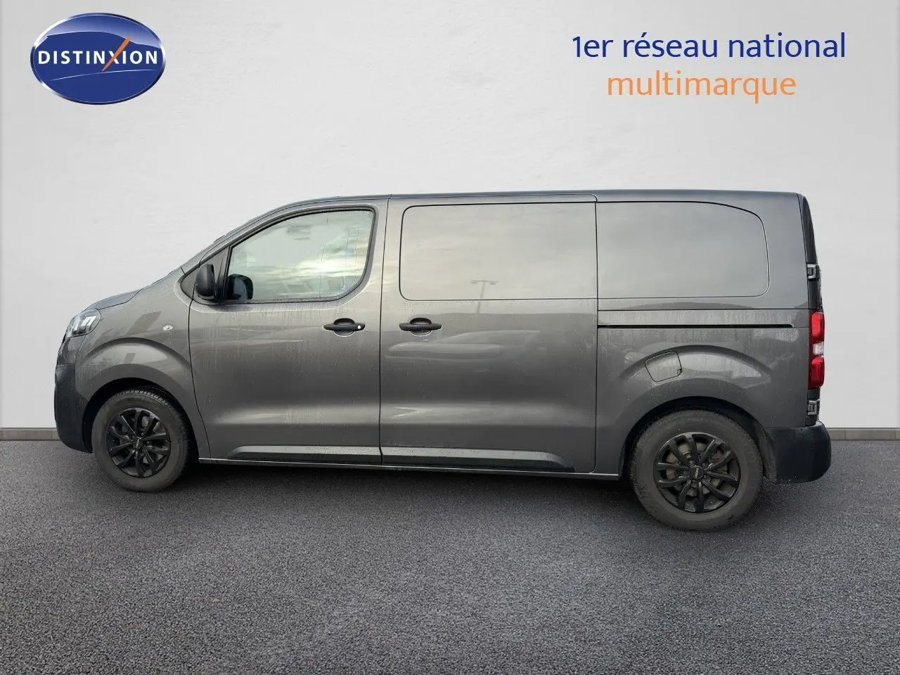 Vue de profil côté gauche d'un Opel Vivaro gris titane métallisé avec jantes noires et carrosserie utilitaire.
