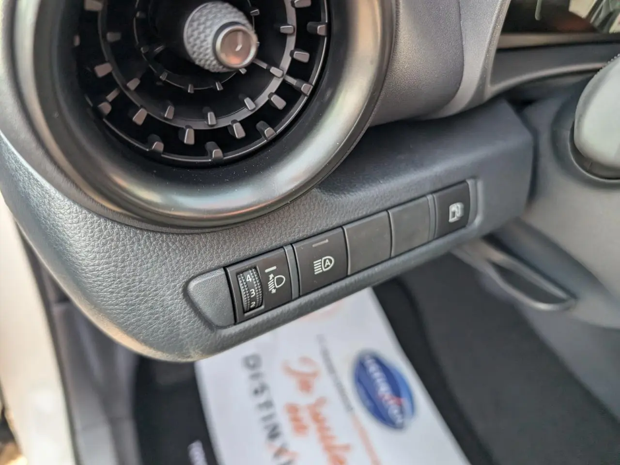 Détail des commandes d’éclairage et ventilation côté gauche dans l’habitacle du Toyota C-HR blanc 2024.