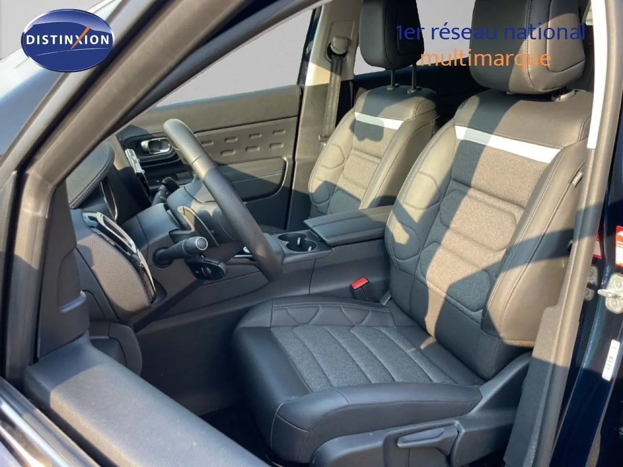 Vue intérieure côté conducteur du Citroën C5 Aircross bleu Eclipse Metal, sièges tissu et cuir gris avec volant multifonction.