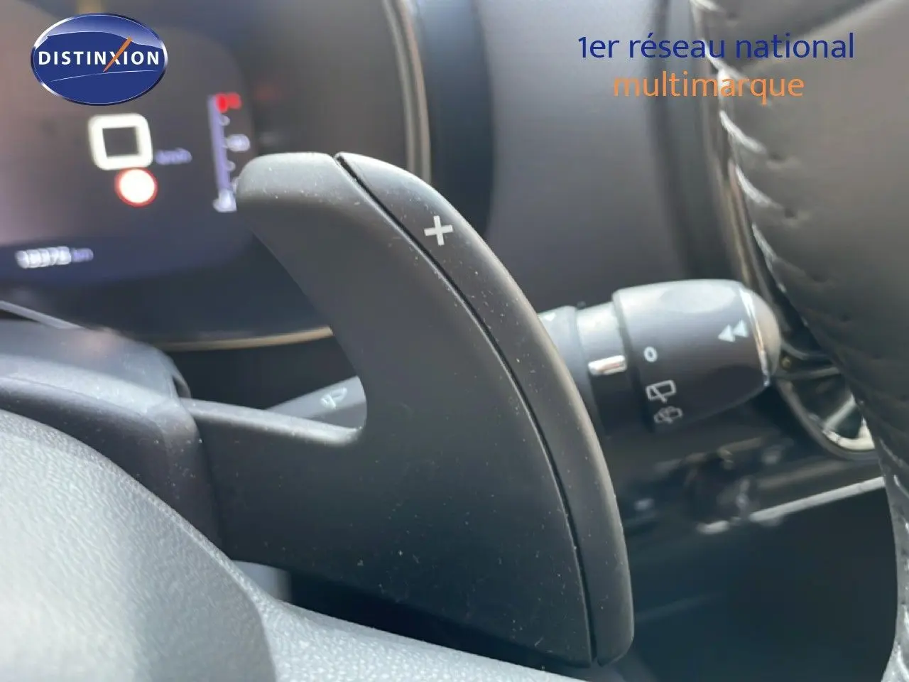 Gros plan sur la palette de changement de vitesse + au volant noir du Citroën C5 Aircross 2025 hybride.