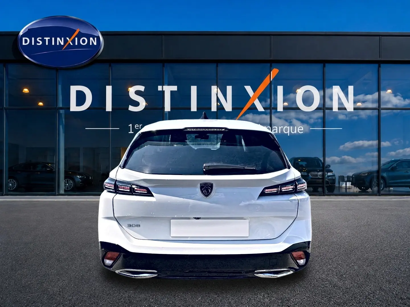 Vue arrière d'une Peugeot 308 SW blanche 2025, avec feux arrière LED et double sortie d'échappement chromée.
