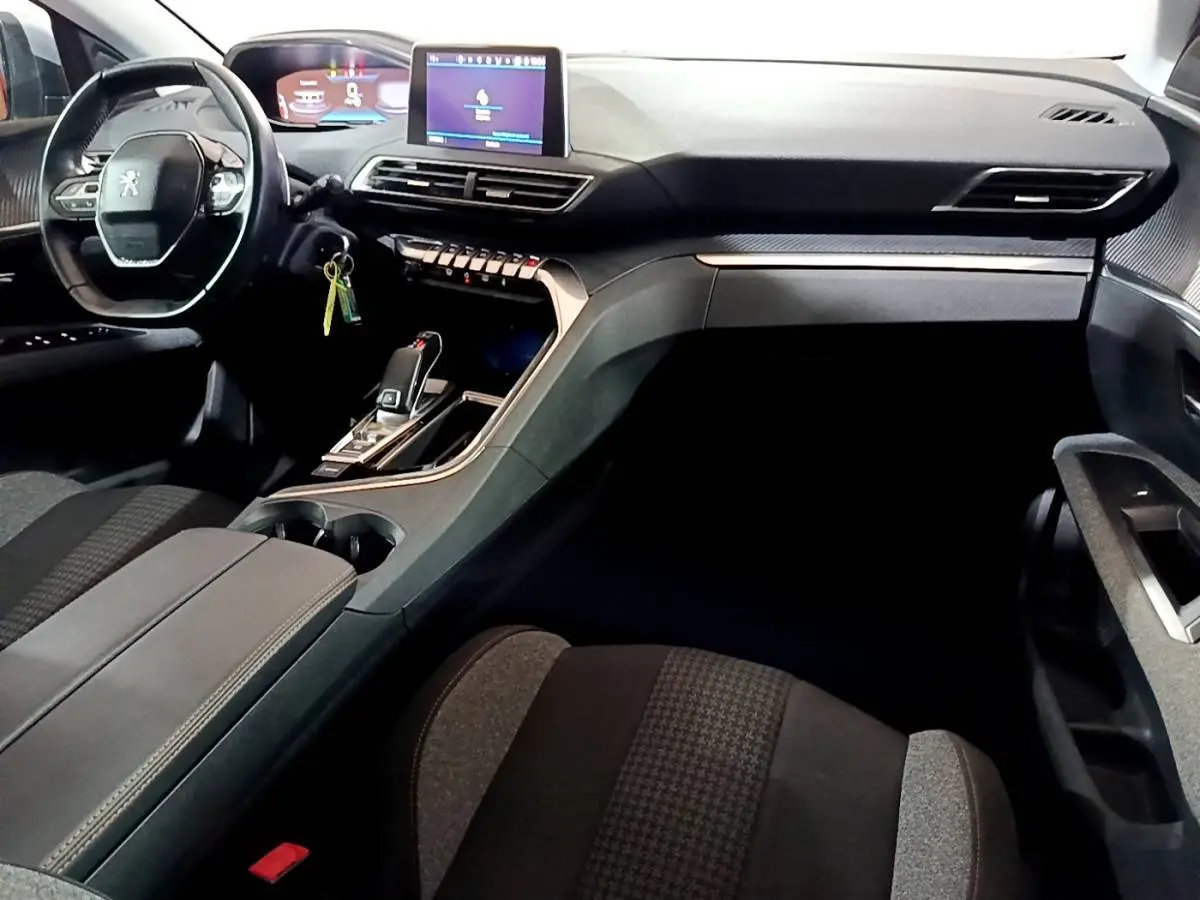 Vue intérieure côté conducteur du Peugeot 5008 2020, tableau de bord moderne avec écran tactile et volant cuir noir.