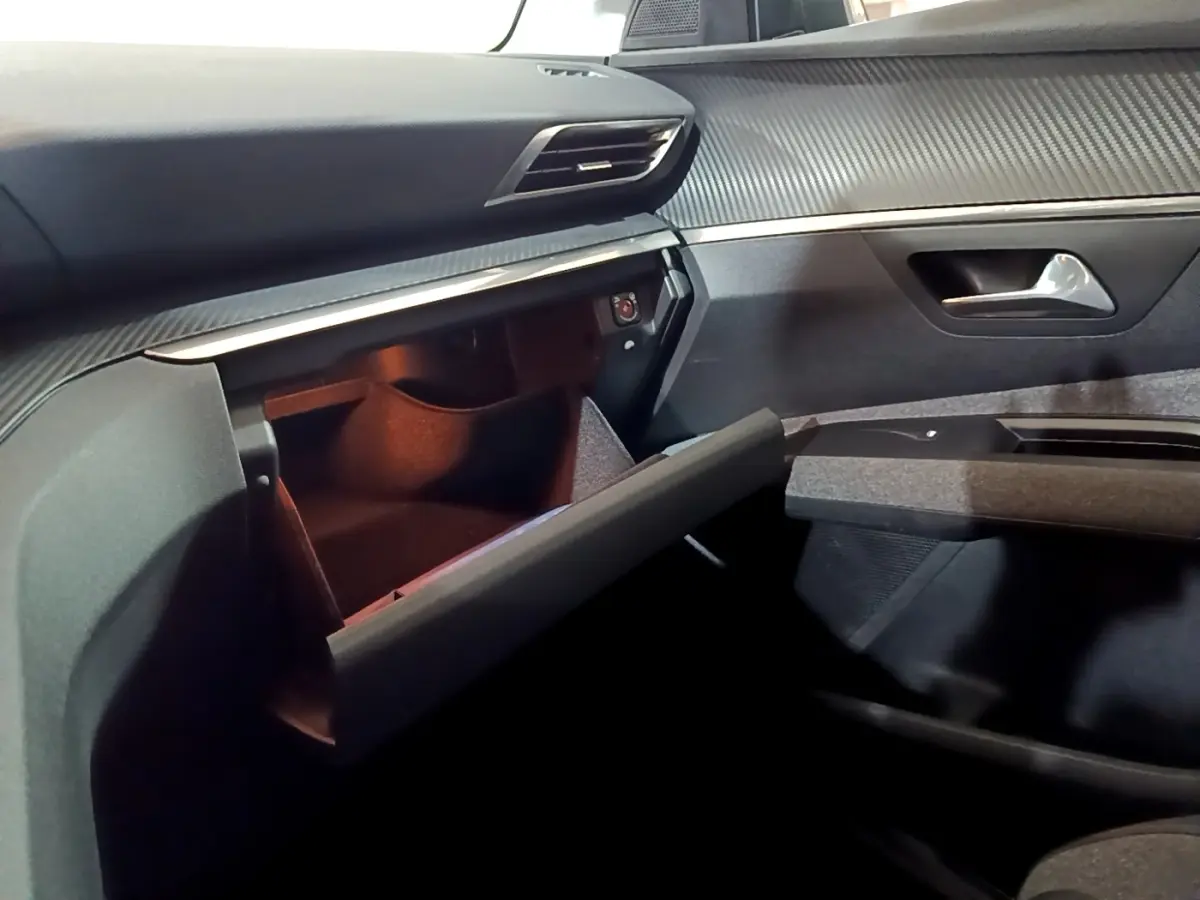 Intérieur du Peugeot 5008 2020, vue côté passager avec boîte à gants ouverte et tableau de bord gris texturé.