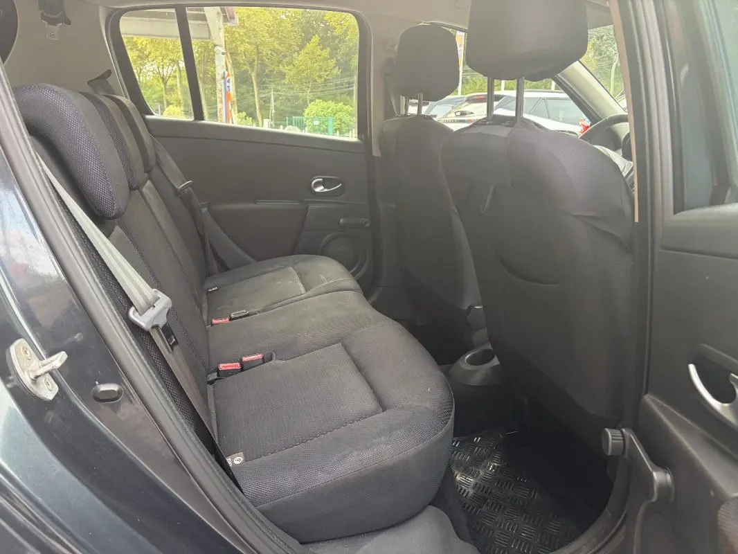 Vue intérieure côté arrière gauche de la Renault Clio III gris, montrant les sièges arrière en tissu noir.