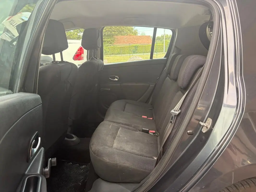 Vue intérieure côté arrière droit de la Renault Clio III gris 2005, montrant les sièges arrière en tissu noir.