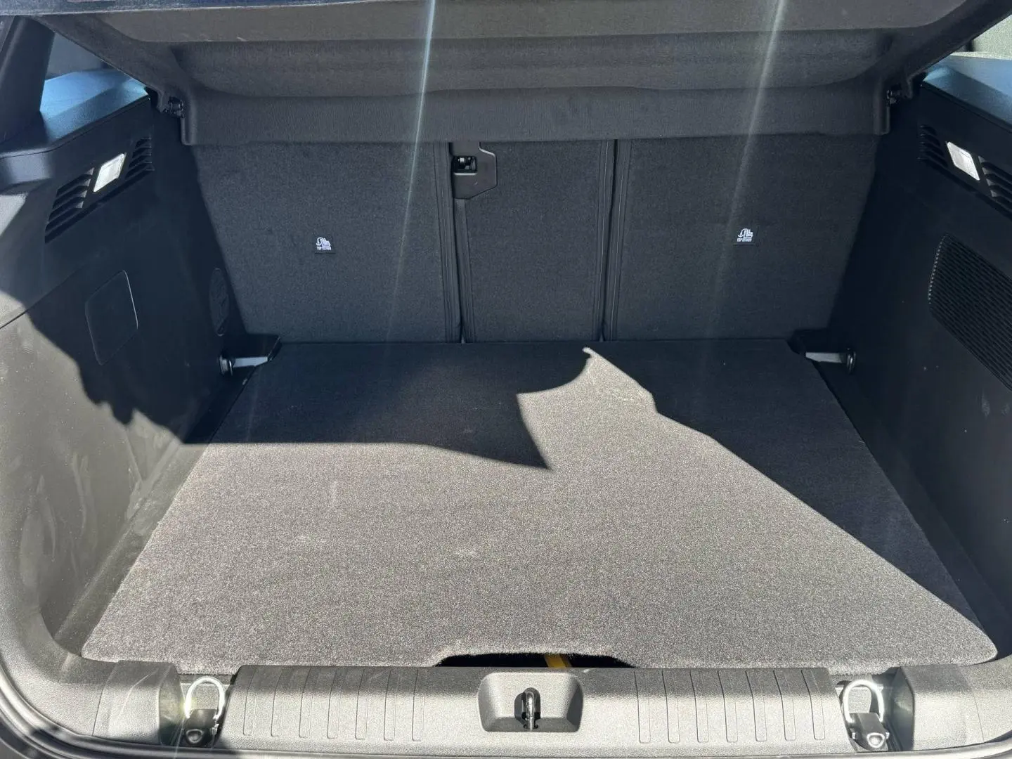 Vue intérieure du coffre spacieux et propre du Jeep Compass 2026, revêtement noir uniforme sans objets visibles.