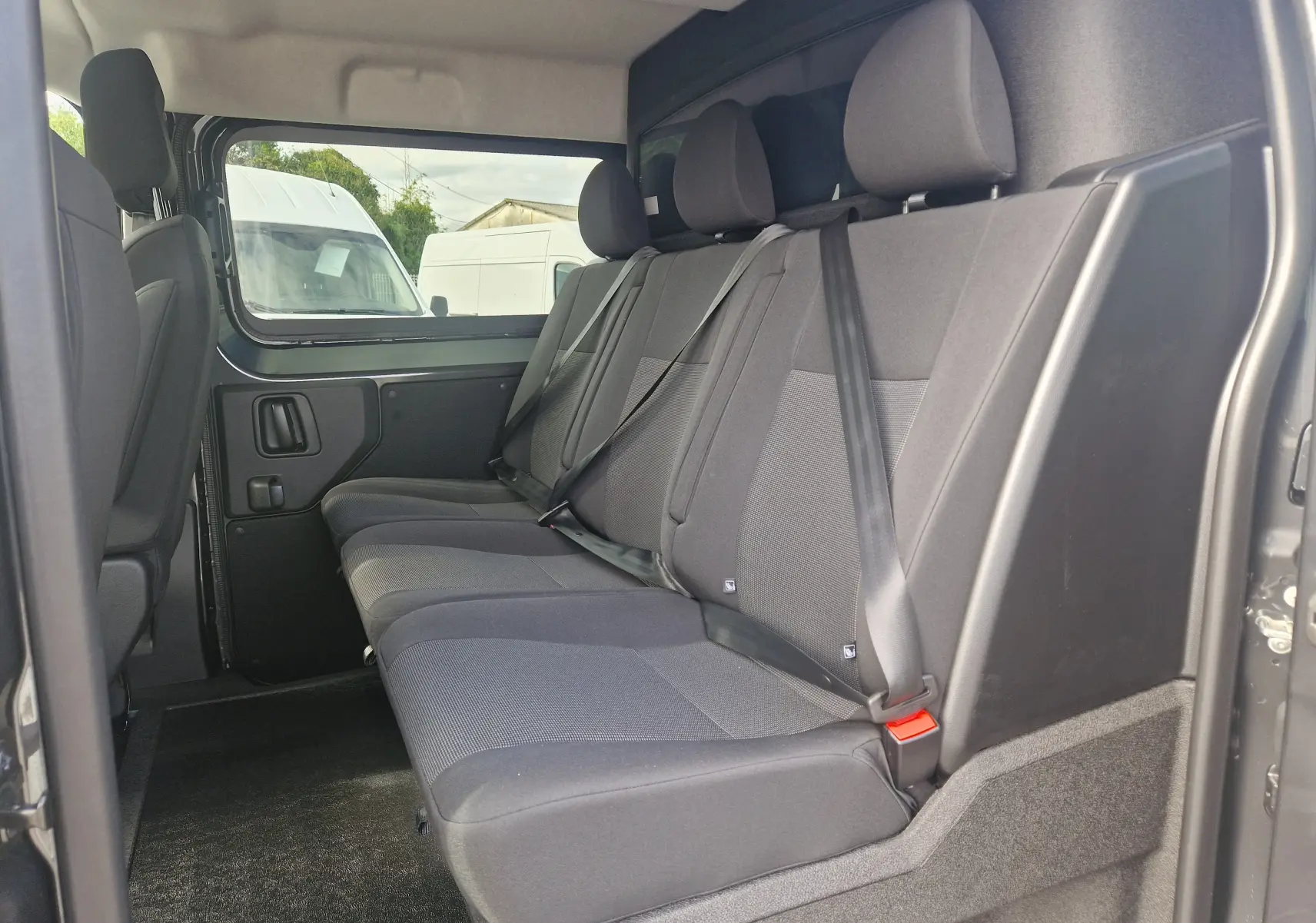 Vue intérieure côté droit des sièges arrière en tissu gris du Citroën Jumpy Cabine Approfondie gris titane.