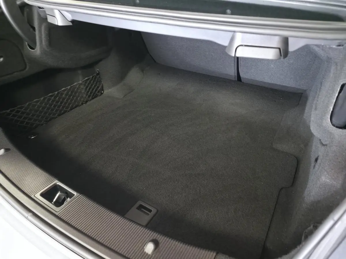Coffre spacieux et propre de la Mercedes Classe E Coupé gris, vue intérieure sans chargement ni accessoires visibles.
