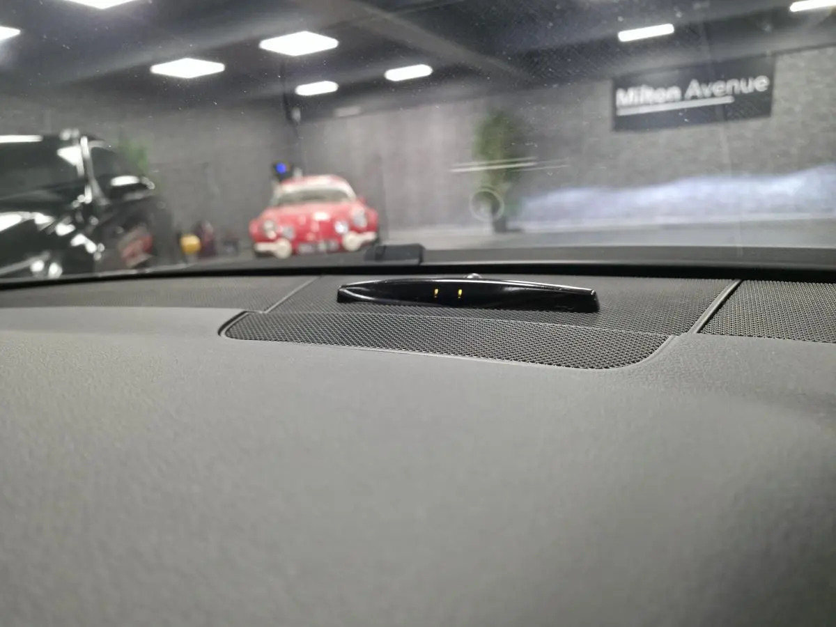 Vue intérieure du tableau de bord gris d'une Mercedes Classe E Coupé E 200 BlueEfficiency 2012 avec haut-parleur central.