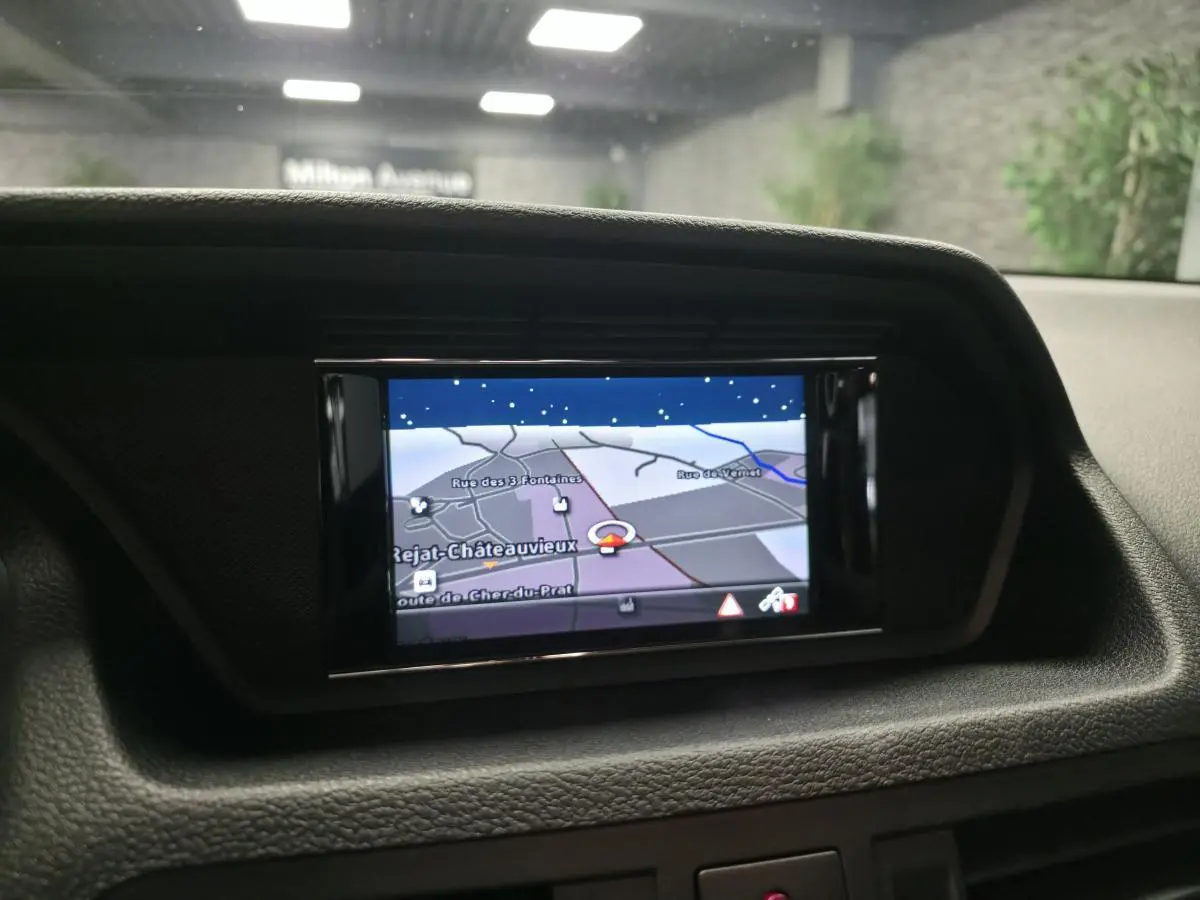 Écran de navigation couleur intégré au tableau de bord d'une Mercedes Classe E Coupé 2012, intérieur noir.