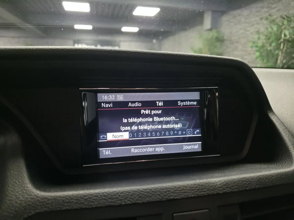 Écran central de navigation et audio affichant la connexion Bluetooth dans une Mercedes Classe E Coupé gris, vue intérieure frontale.