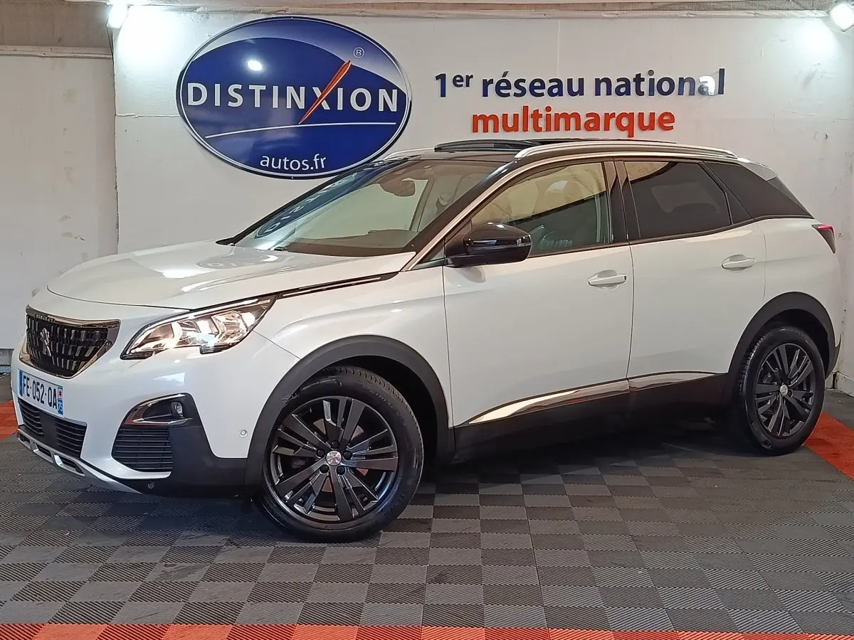 Peugeot 3008 blanc vue 3/4 avant droit, avec jantes noires et toit noir contrasté en intérieur showroom.