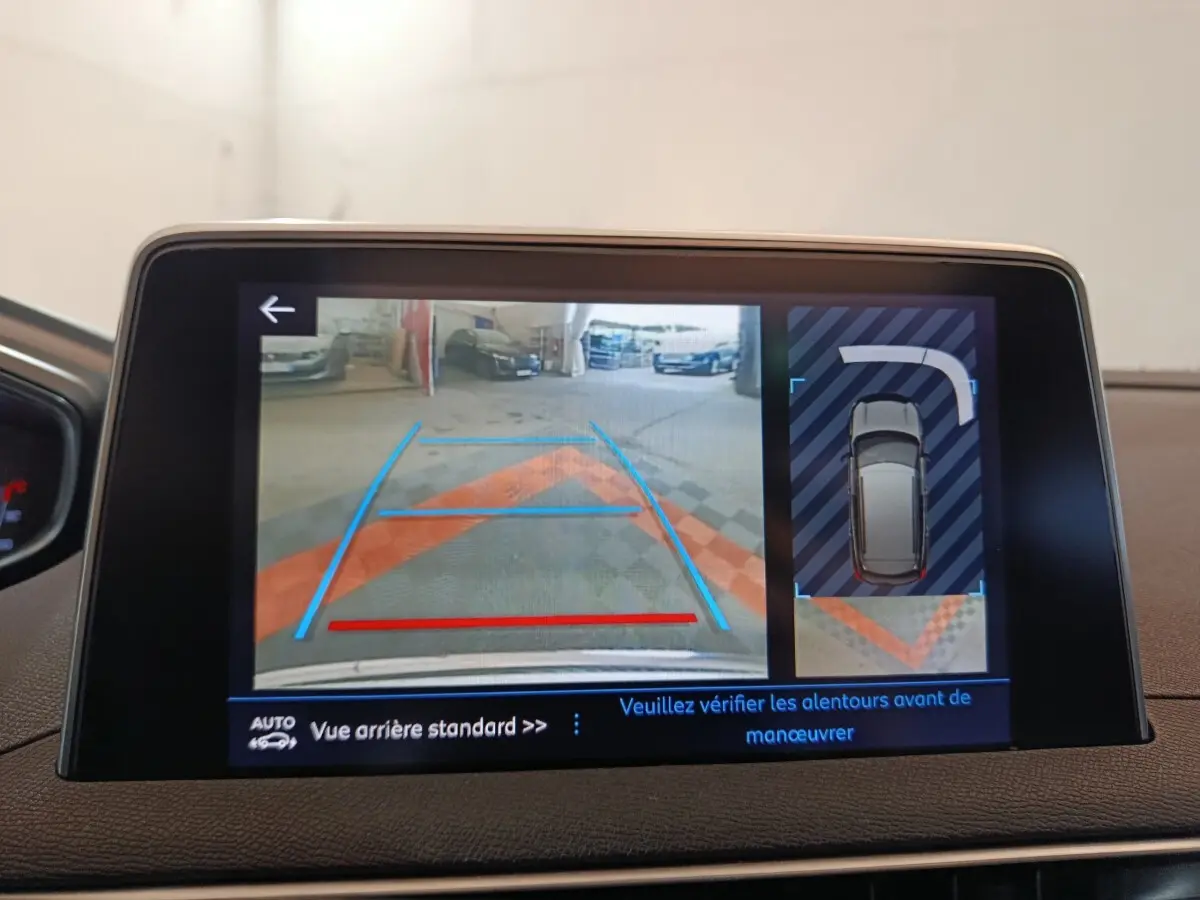 Écran tactile intérieur montrant la caméra de recul et l’aide au stationnement du Peugeot 3008 blanc.